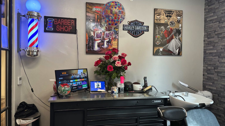 Barber station with shampoo bowl, fresh flowers and a barber pole inside Joni's Gentleman's Cuts