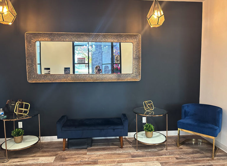 Waiting area with blue velvet seating and gold accents near Joni's suite in Lone Tree