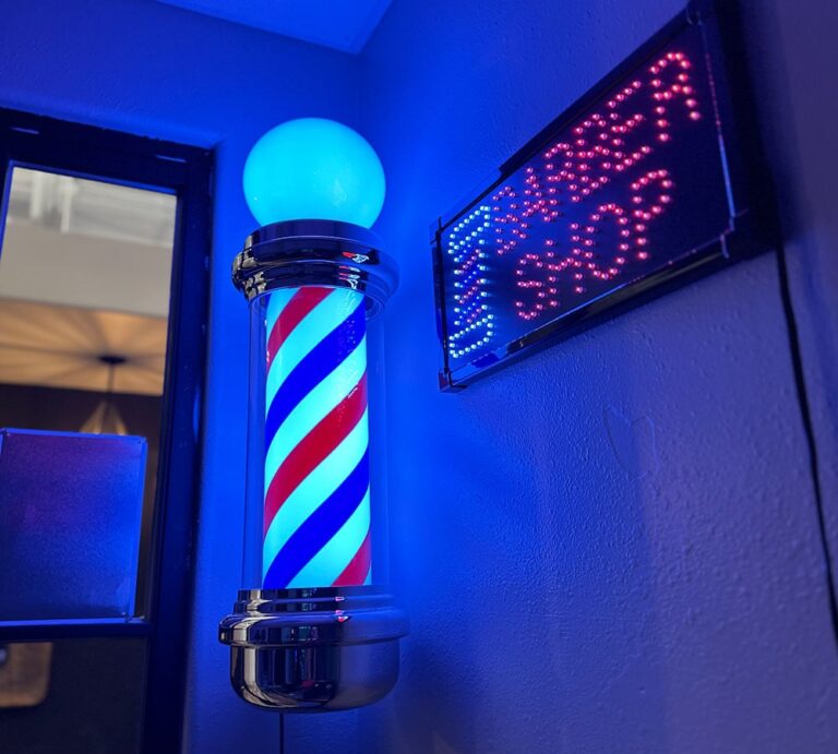 Lit barber pole and neon barber shop sign at Joni's Gentleman's Cuts, Lone Tree