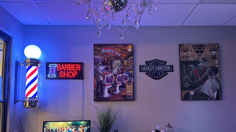 Barber pole, neon barber shop sign and vintage barbershop posters inside Joni's Gentleman's Cuts